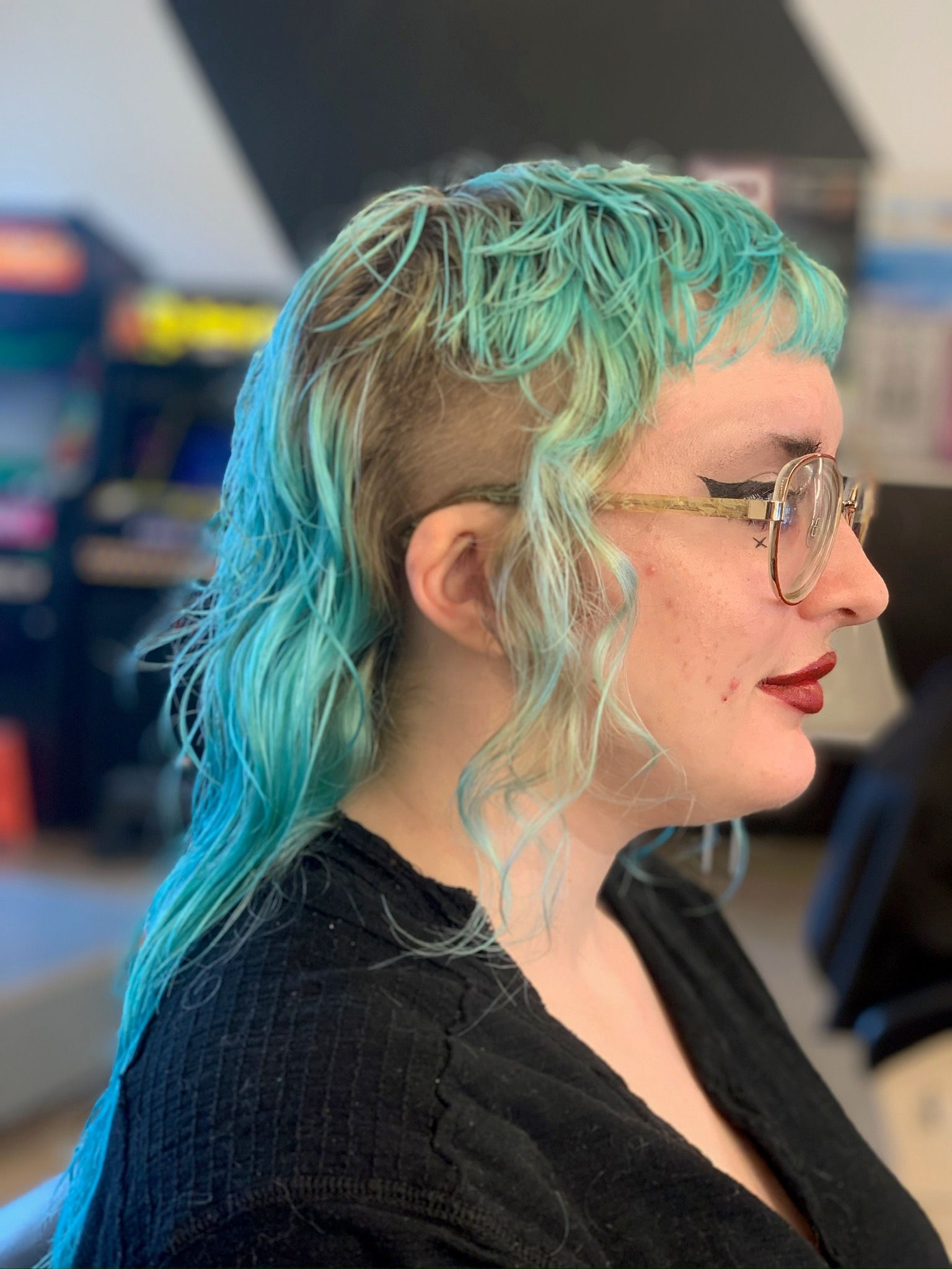 Aqua blue mullet with shaved sides and loose face-framing texture