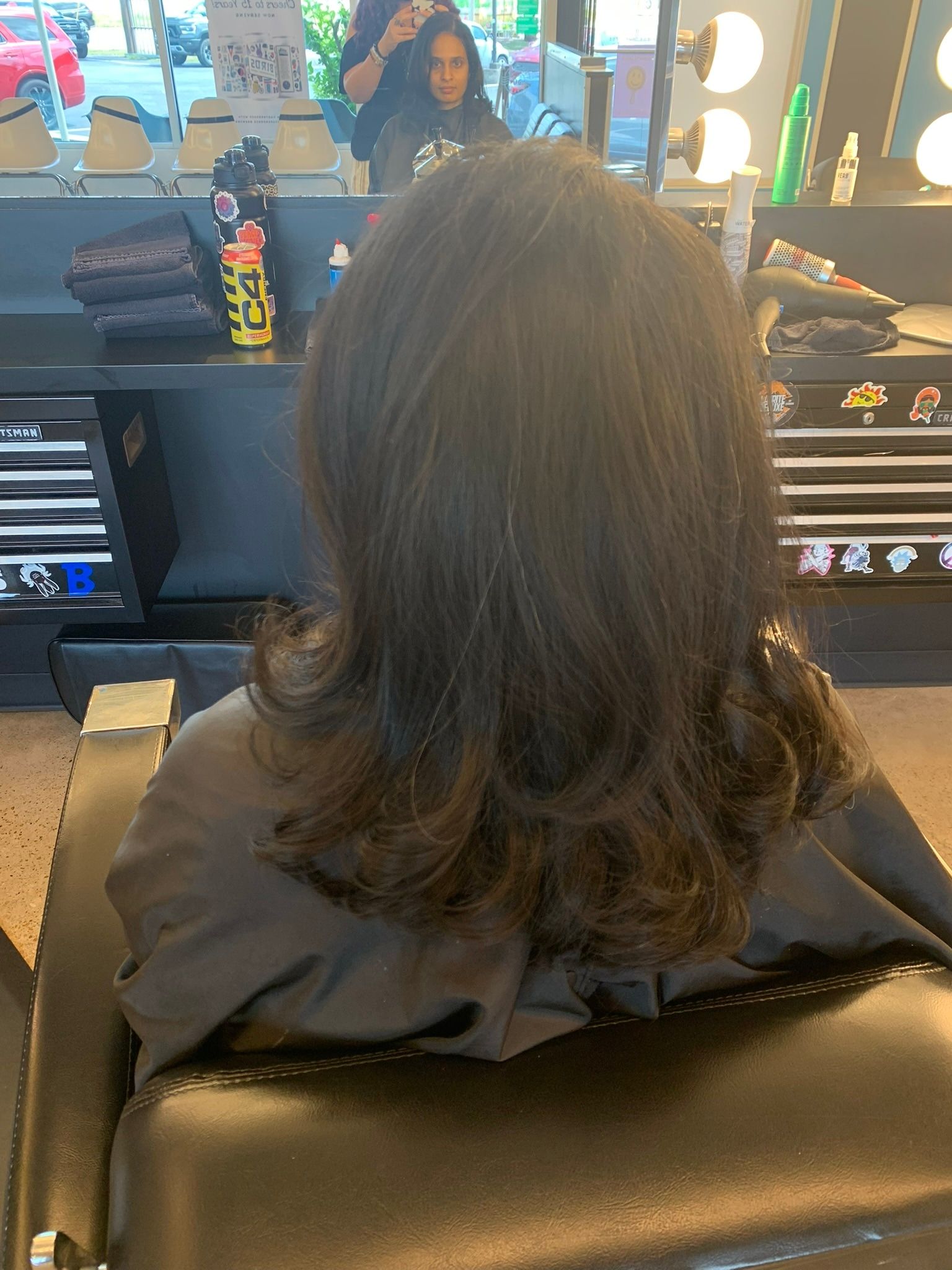 Long black layered haircut with curled ends viewed from the back