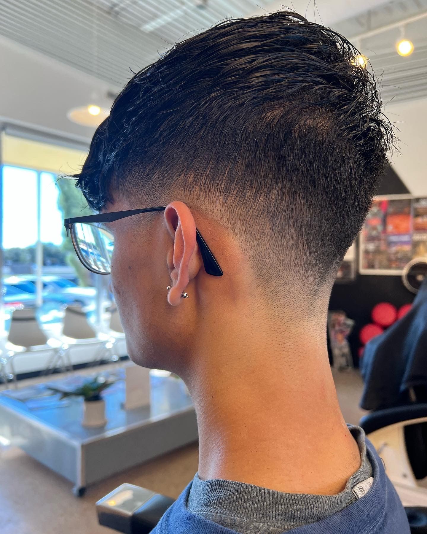 Short dark haircut with a low tapered fade around the nape