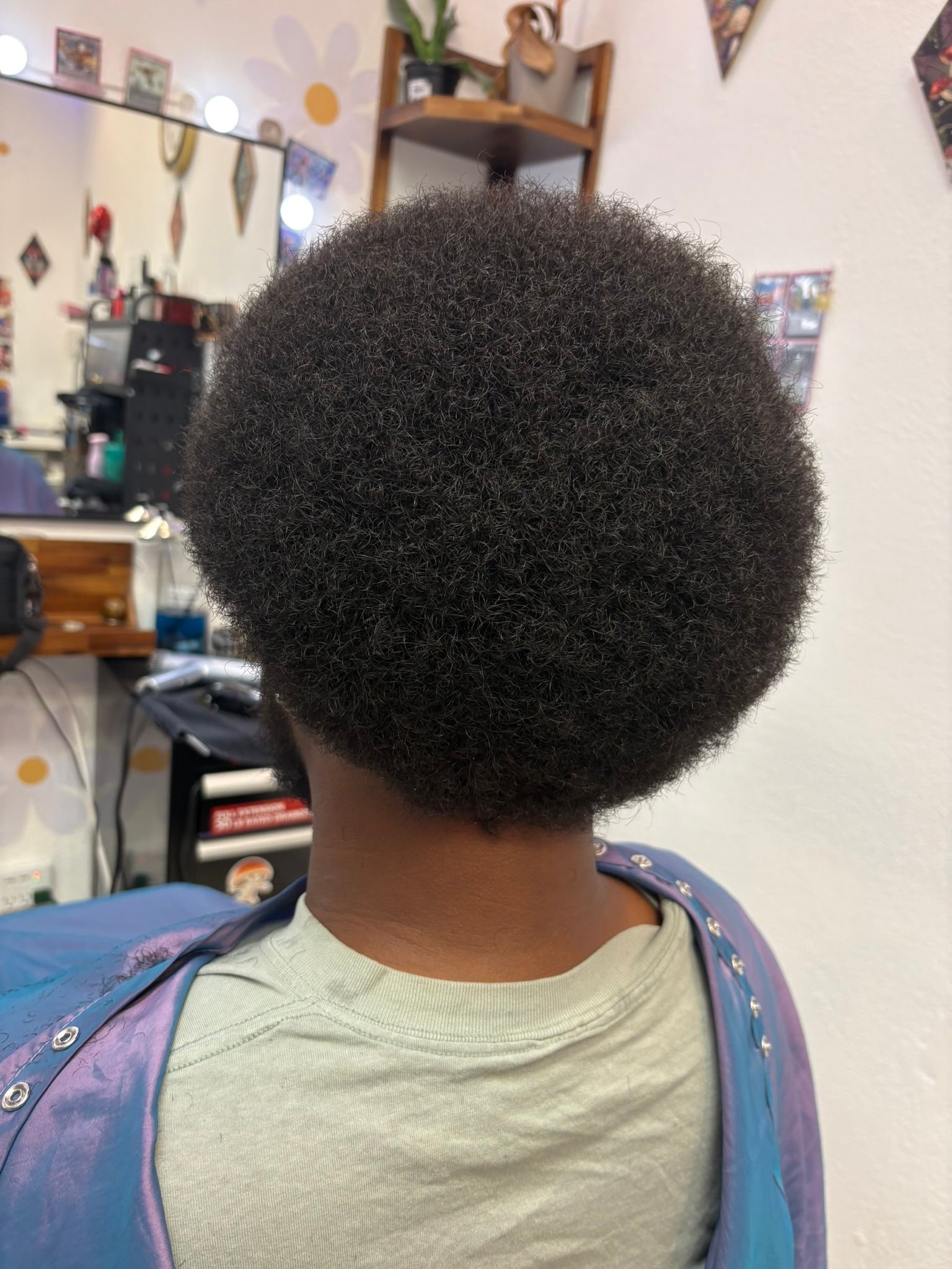 Rounded natural hair cut with a clean tapered neckline